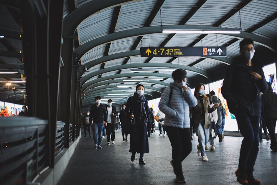 Commuters in masks navigating a public transport terminal