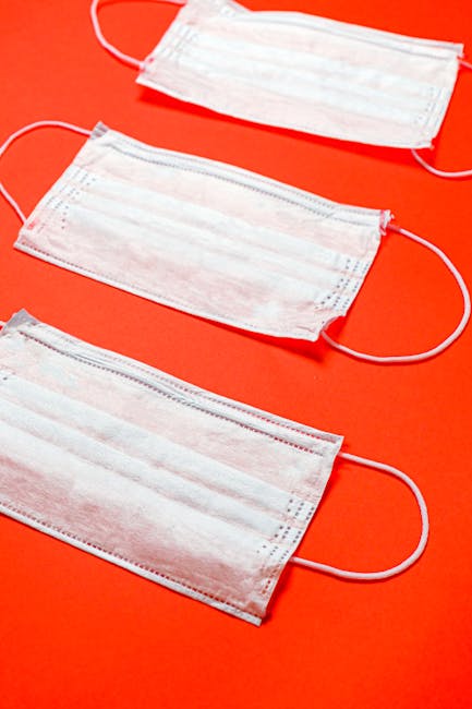 Surgical masks laid out on a red background